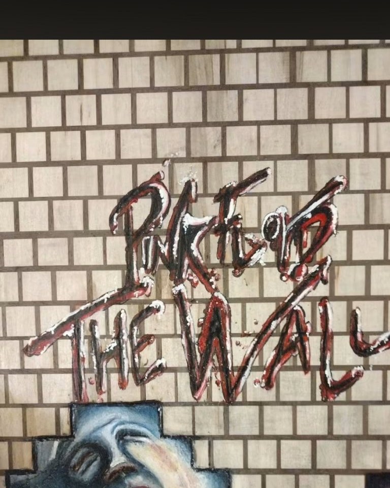 Pink Floyd The Wall inspired mural painted across a block-pattern wall